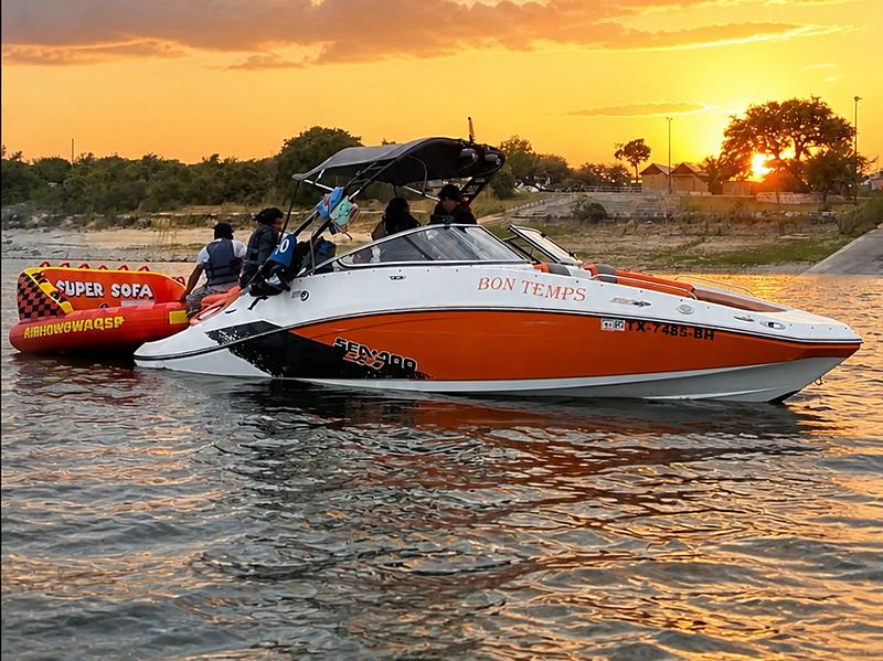 Our orange boat with captain and the super sofa tube on Lake Travis at sunset